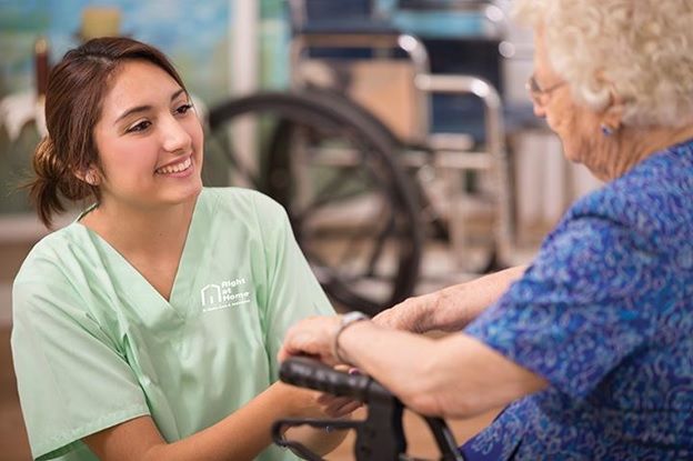 caregiver helping senior client with moving around in wheelchair