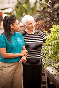 Carer and older lady in greenhouse