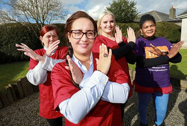 four right at home ireland women standing outside with their arms crossed forming Xs