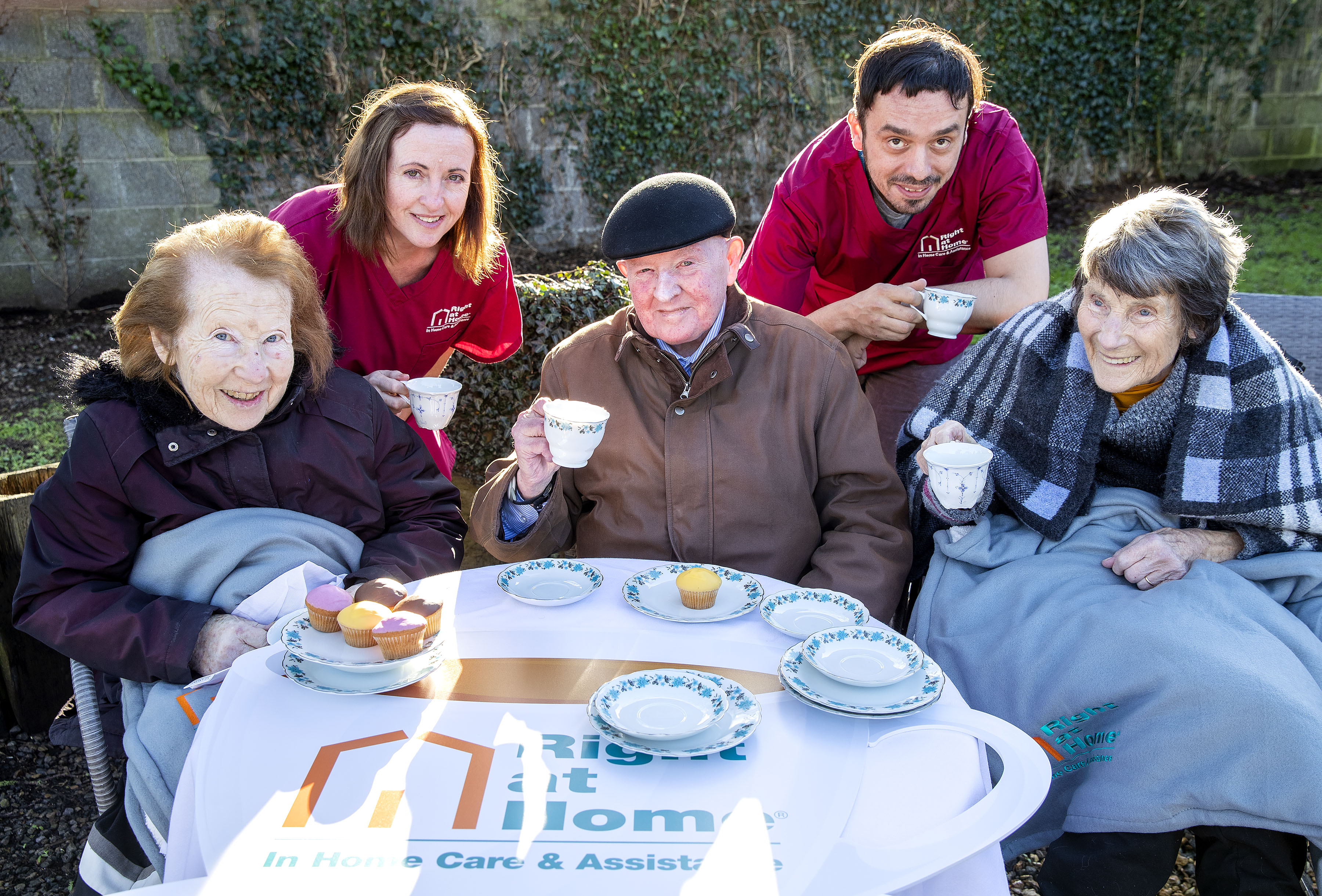 two carers and three seniors enjoying cups of coffee