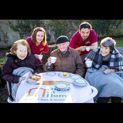 two carers and three seniors enjoying cups of coffee