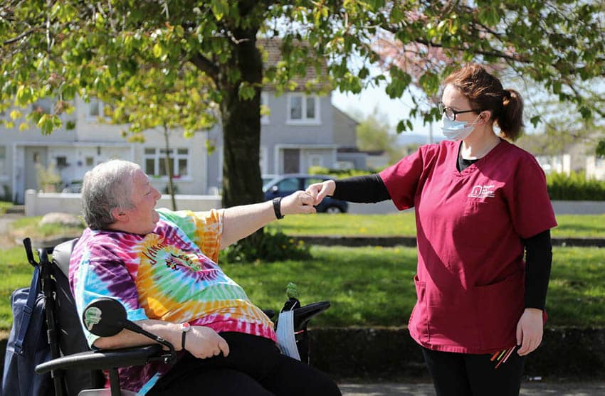 Carer with individual in wheelchair