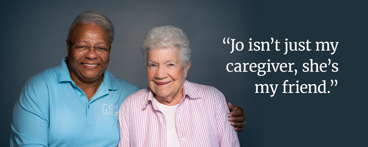 a female carer and senior female standing together with text: "Jo isn't just my caregiver, she's my friend."