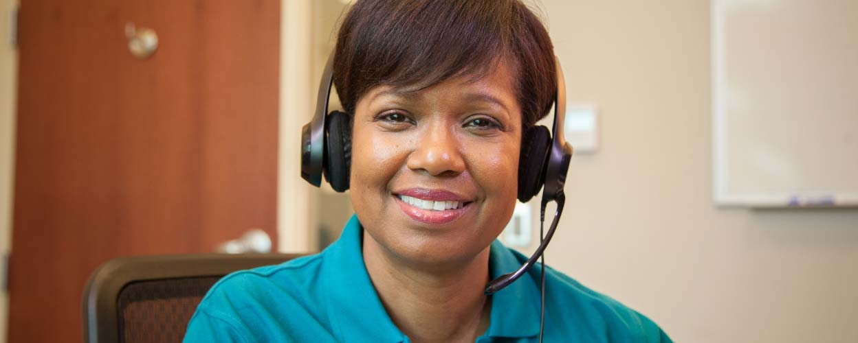 A female Right at Home employee wearing a hands free phone headset while smiling